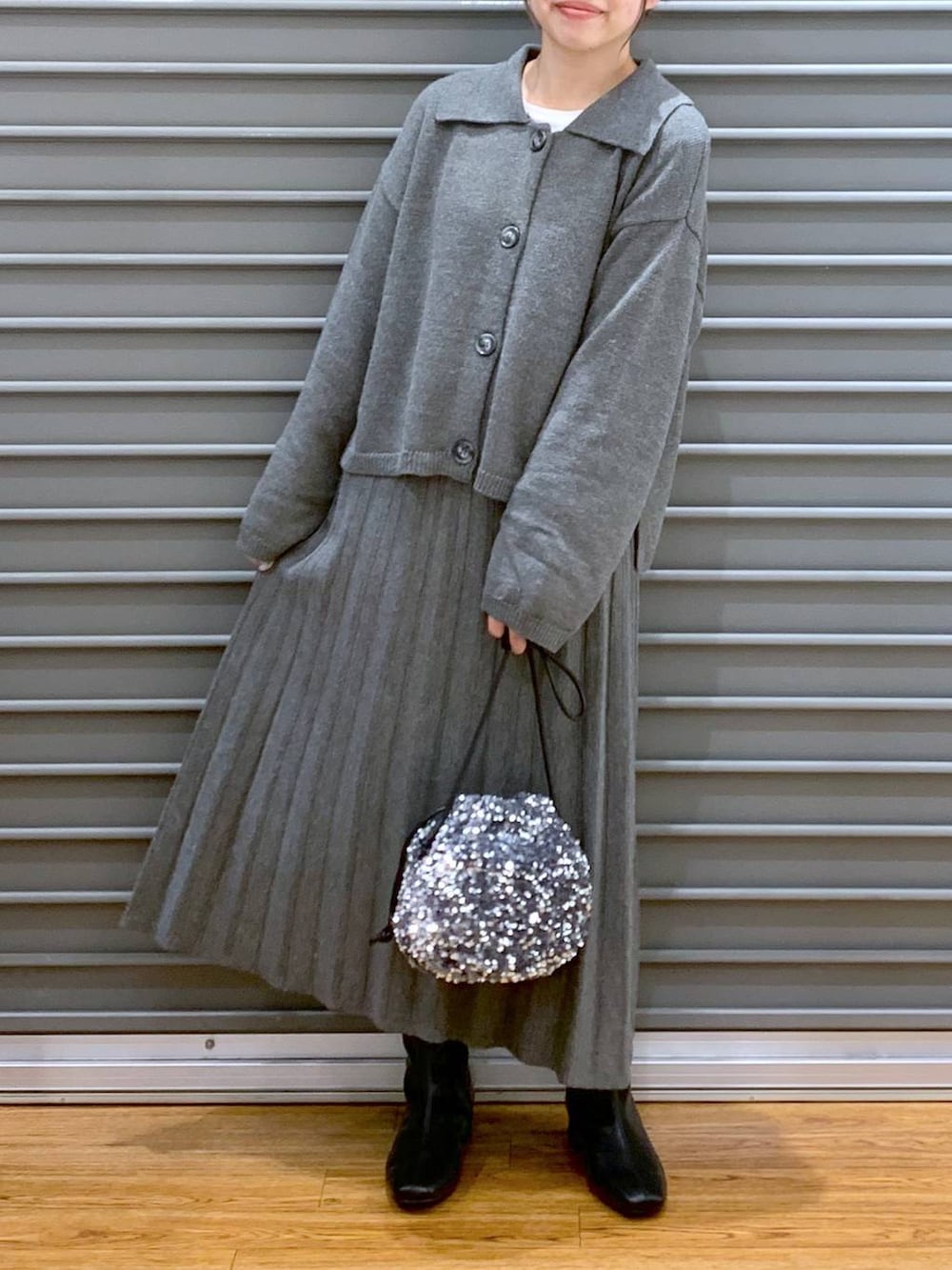 シルバー系のショルダーバッグ、ブラック系のブーツ、グレー系のワンピースを着用したレディースの秋コーディネートの3枚目の写真