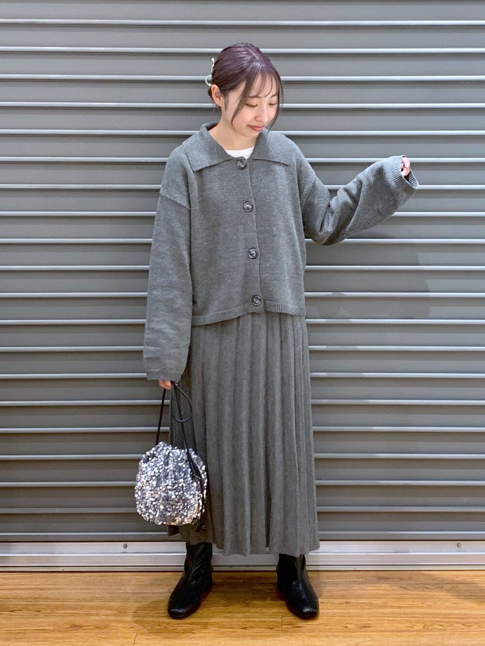 シルバー系のショルダーバッグ、ブラック系のブーツ、グレー系のワンピースを着用したレディースの秋コーディネートの4枚目の写真