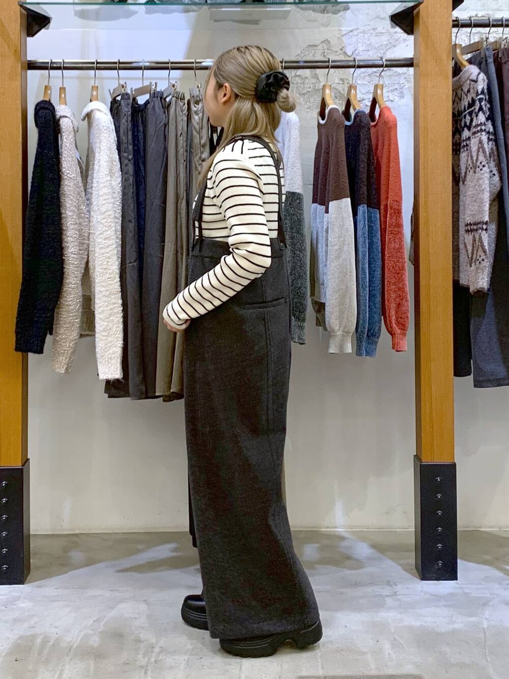 グレー系のその他パンツ、ホワイト系のニット/セーター、ブラック系のブーツを着用したレディースの秋コーディネートの5枚目の写真
