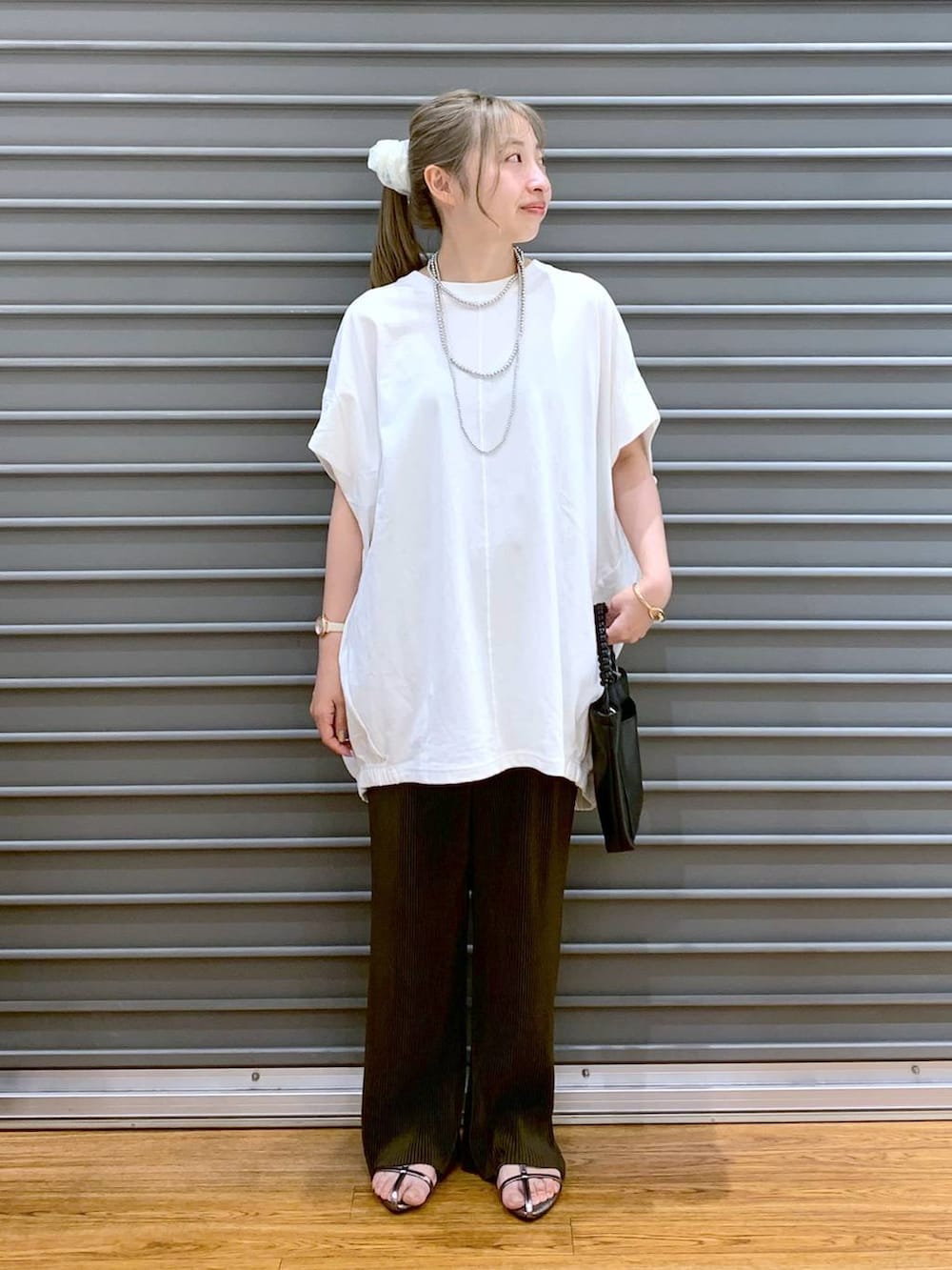 その他のサンダル、ブラウン系のその他パンツ、ブラック系のショルダーバッグを着用したレディースの夏コーディネートの6枚目の写真