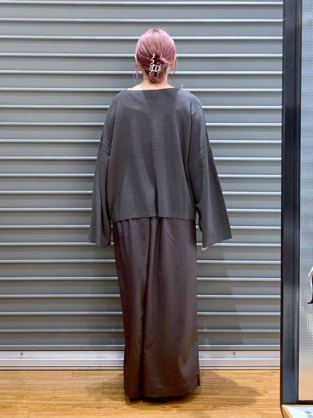 ホワイト系のショルダーバッグ、グレー系のニット/セーター、ブラック系のブーツを着用したレディースの秋コーディネートの2枚目の写真