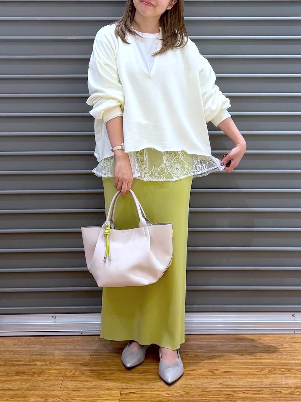 グリーン系のスカート、ホワイト系のTシャツ/カットソー、シルバー系のパンプスを着用したレディースの冬コーディネートの5枚目の写真