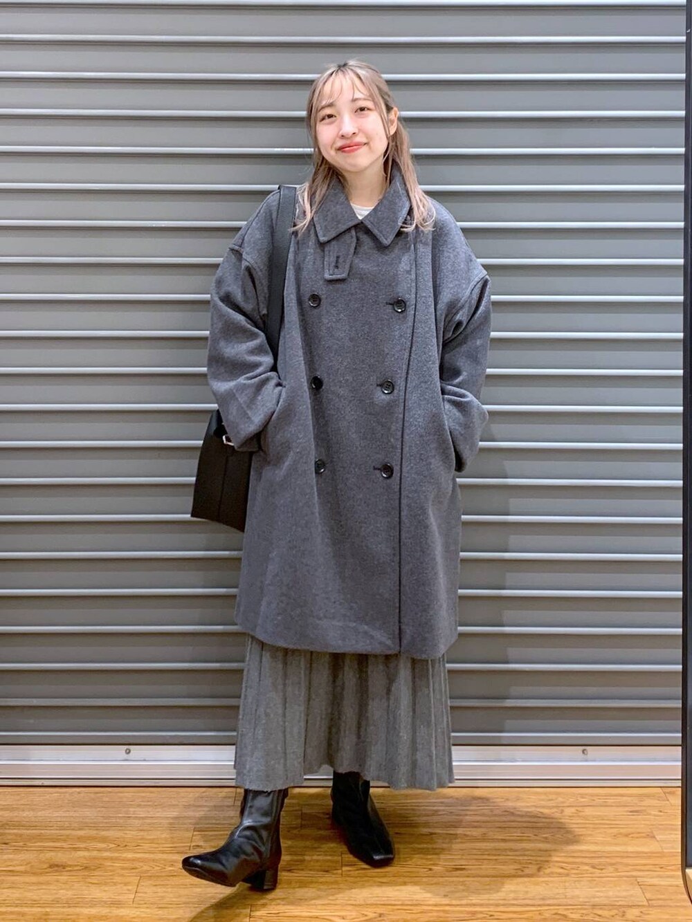 グレー系のその他アウター、ブラック系のブーツ、グレー系のワンピースを着用したレディースの冬コーディネートの9枚目の写真