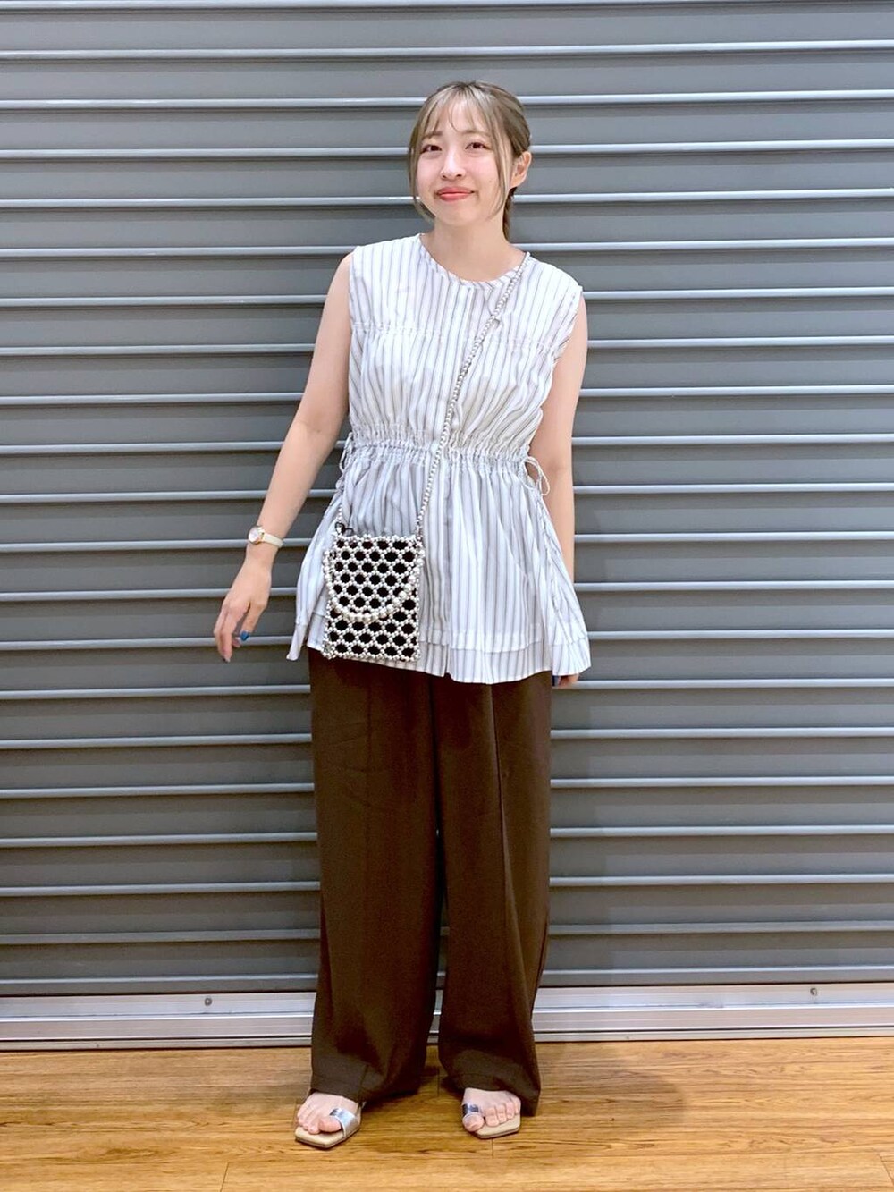 ブラウン系のその他パンツ、シルバー系のショルダーバッグ、ベージュ系のサンダルを着用したレディースの夏コーディネートの7枚目の写真