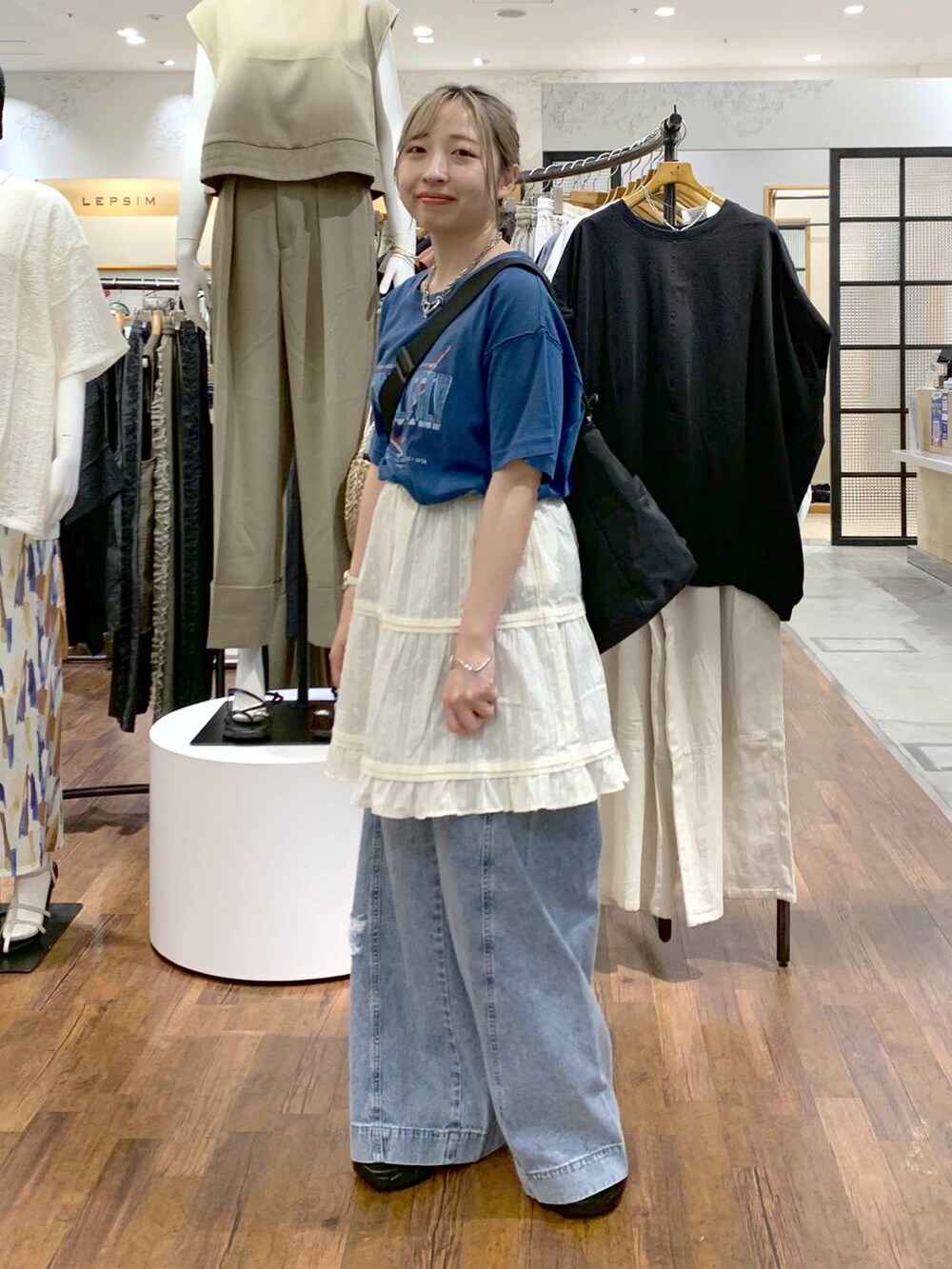 ブルー系のデニムパンツ、ブラック系のサンダル、ブラック系のショルダーバッグを着用したレディースの夏コーディネートの7枚目の写真