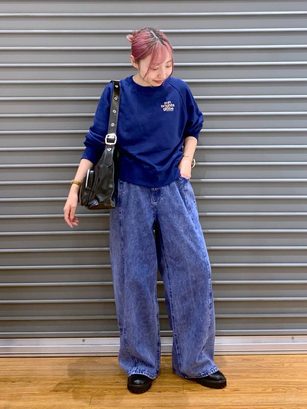 ブラック系のブーツ、ブラック系のショルダーバッグ、ブルー系のスウェットを着用したレディースの冬コーディネートの4枚目の写真