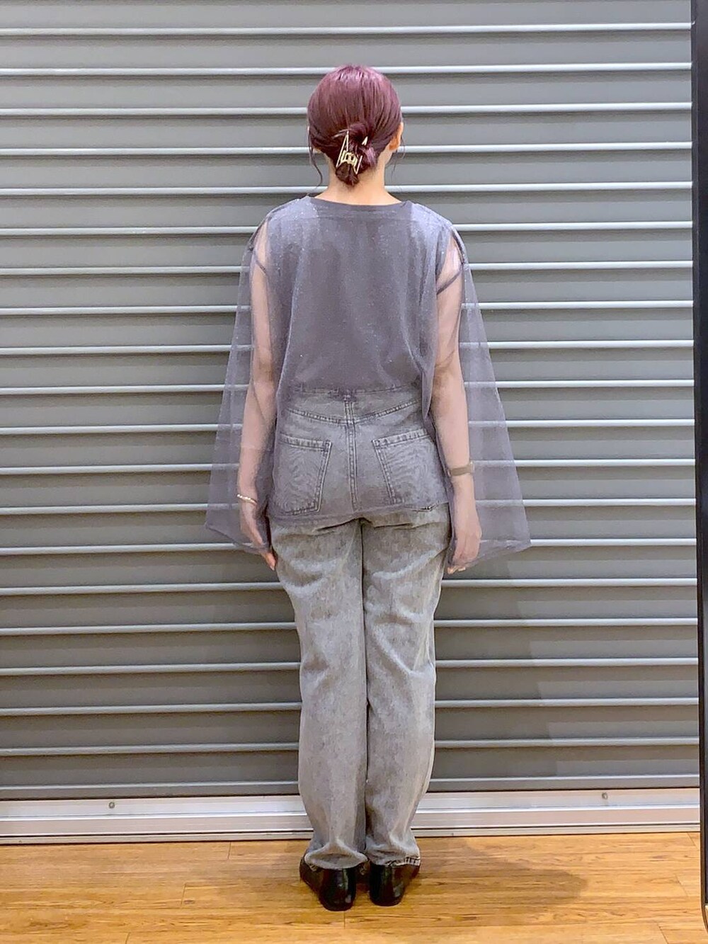 グレー系のデニムパンツ、ブラック系のパンプス、ブラック系のボストンバッグを着用したレディースの秋コーディネートの2枚目の写真