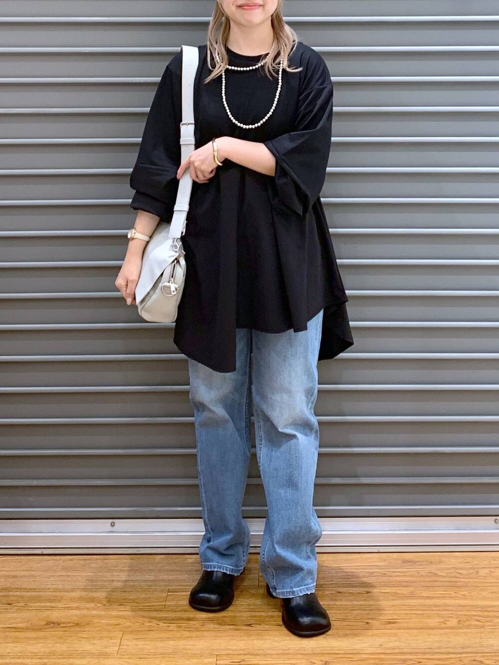 ブルー系のデニムパンツ、グレー系のショルダーバッグ、ブラック系のその他シューズを着用したレディースの秋コーディネートの5枚目の写真