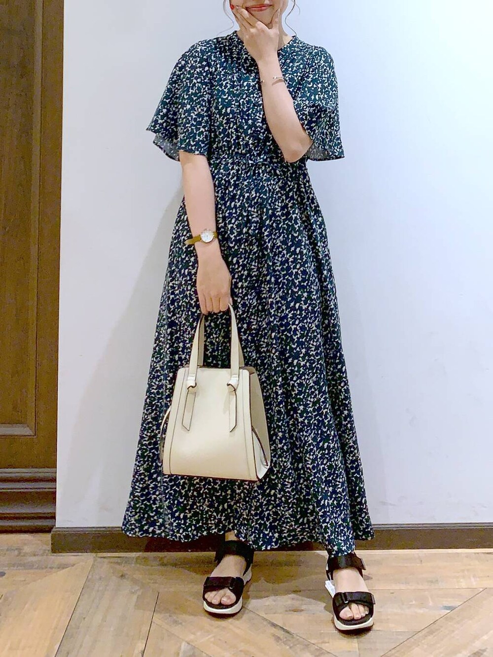 ホワイト系のショルダーバッグ、ブラック系のサンダル、グリーン系のワンピースを着用したレディースの夏コーディネートの3枚目の写真