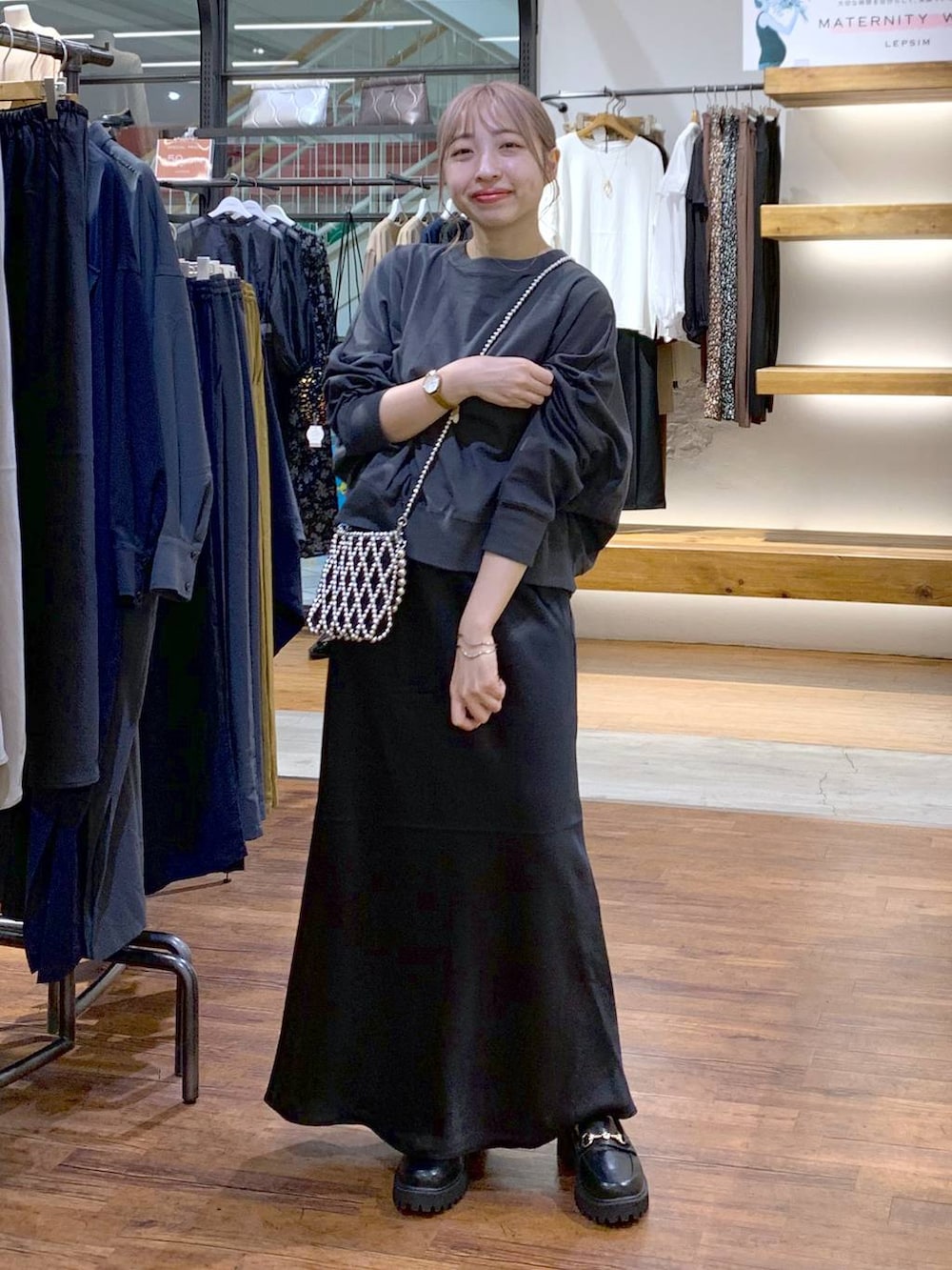 シルバー系のショルダーバッグ、ブラック系のスカート、ブラック系のローファーを着用したレディースの秋コーディネートの5枚目の写真