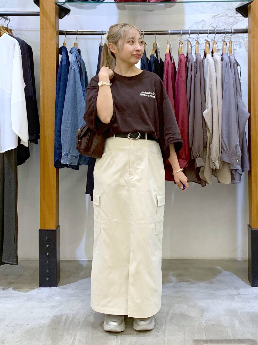 ホワイト系のスカート、ブラウン系のショルダーバッグ、ブラウン系のTシャツ/カットソーを着用したレディースの秋コーディネートの4枚目の写真