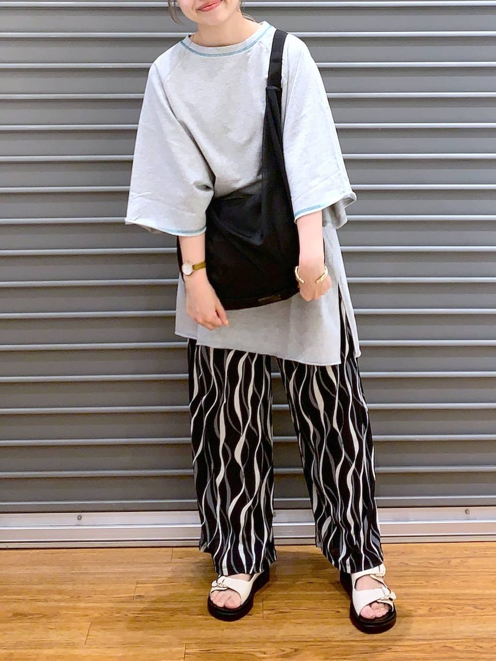 ブラック系のショルダーバッグ、グレー系のTシャツ/カットソー、ブラック系のその他パンツを着用したレディースの春コーディネートの6枚目の写真