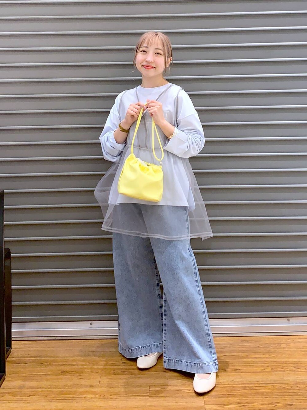 ブルー系のデニムパンツ、ホワイト系のバレエシューズ、イエロー系のショルダーバッグを着用したレディースの春コーディネートの5枚目の写真