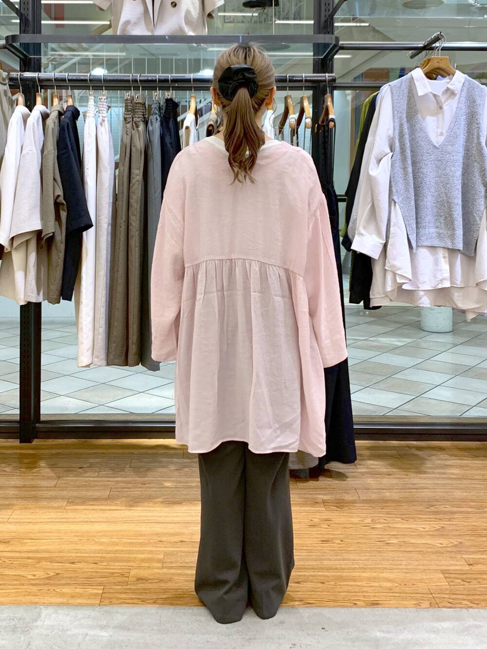 ホワイト系のTシャツ/カットソー、グレー系のスラックス、ブラック系のショルダーバッグを着用したレディースの春コーディネートの2枚目の写真