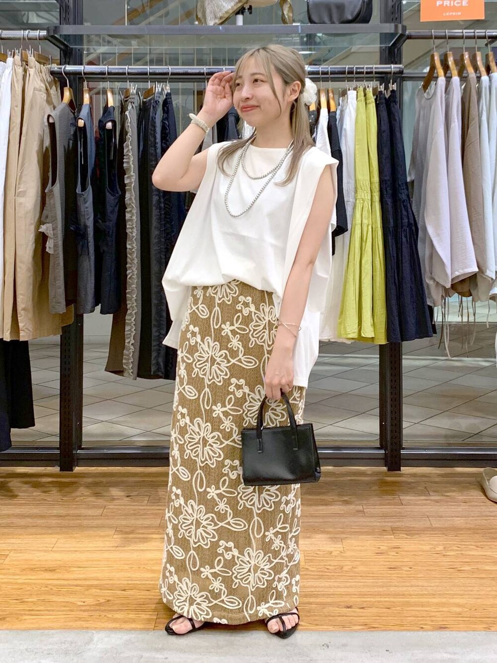 ホワイト系のTシャツ/カットソー、ブラック系のサンダル、ブラック系のショルダーバッグを着用したレディースの夏コーディネートの7枚目の写真