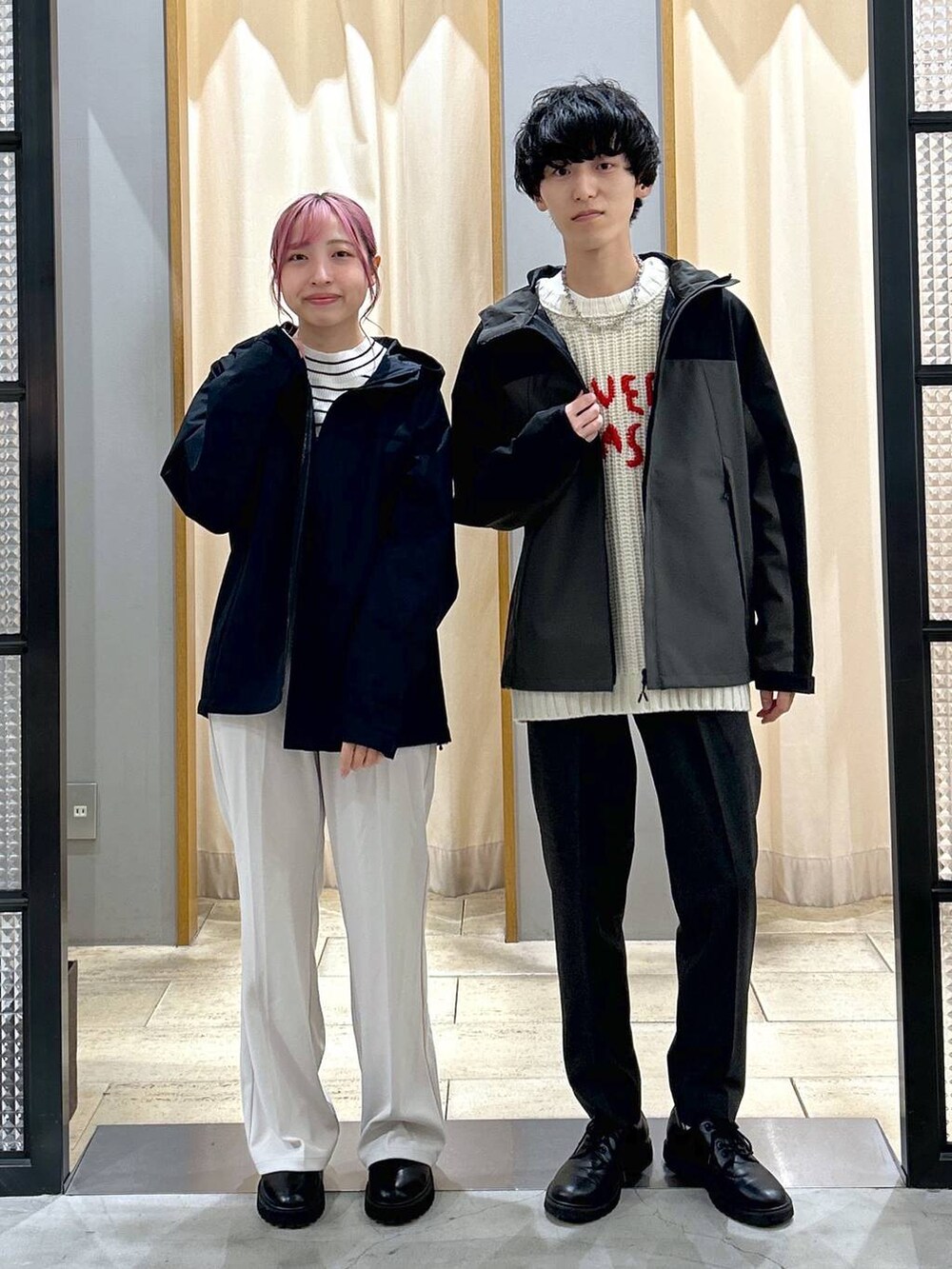 グレー系のスラックス、ブラック系のブーツ、ホワイト系のニット/セーターを着用したレディースの冬コーディネートの4枚目の写真