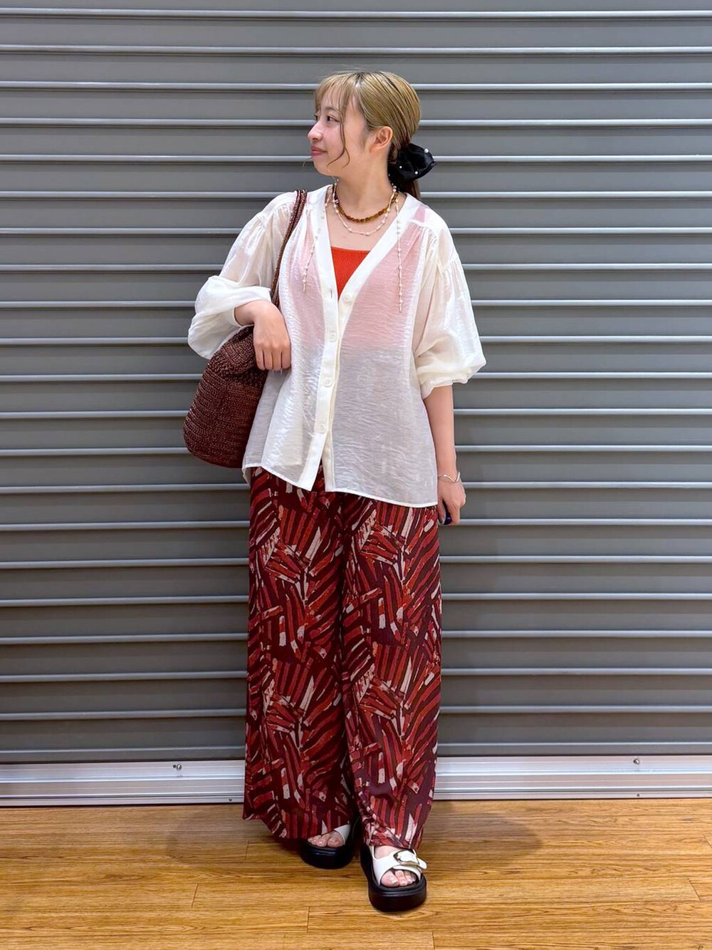 レッド系のその他パンツ、ホワイト系のサンダル、ベージュ系のシャツ/ブラウスを着用したレディースの夏コーディネートの4枚目の写真