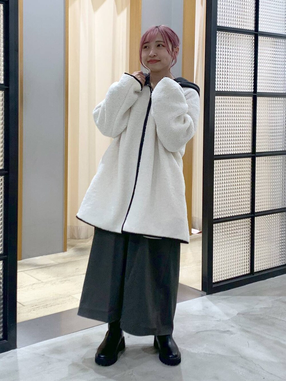 ブラック系のブーツ、ホワイト系のその他アウター、グレー系のワンピースを着用したレディースの秋コーディネートの4枚目の写真