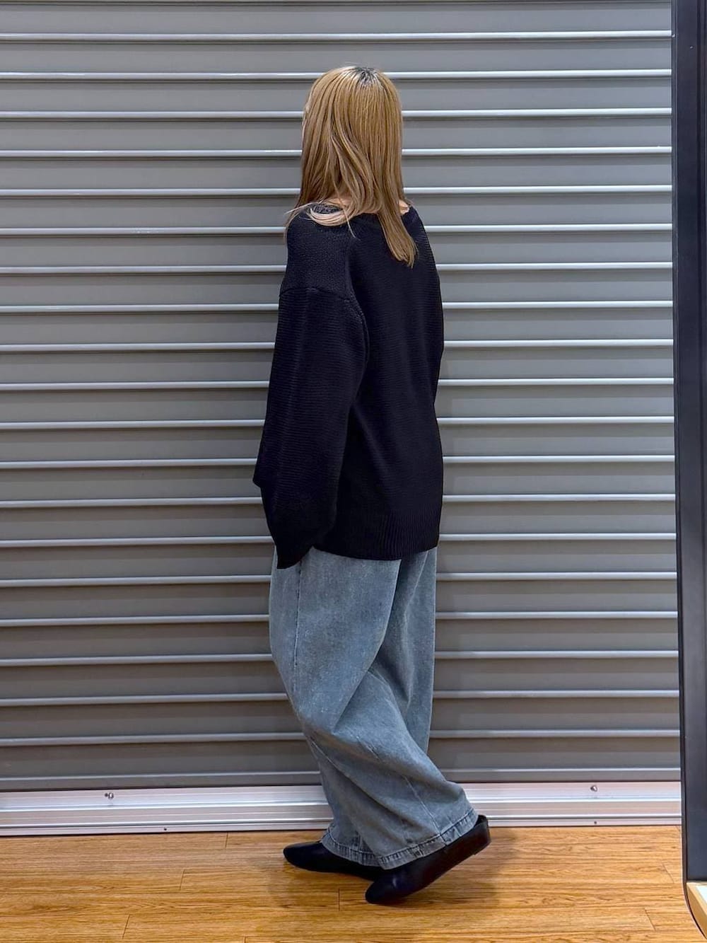 ブラック系のニット/セーター、ブルー系のデニムパンツ、シルバー系のネックレスを着用したレディースの春コーディネートの3枚目の写真