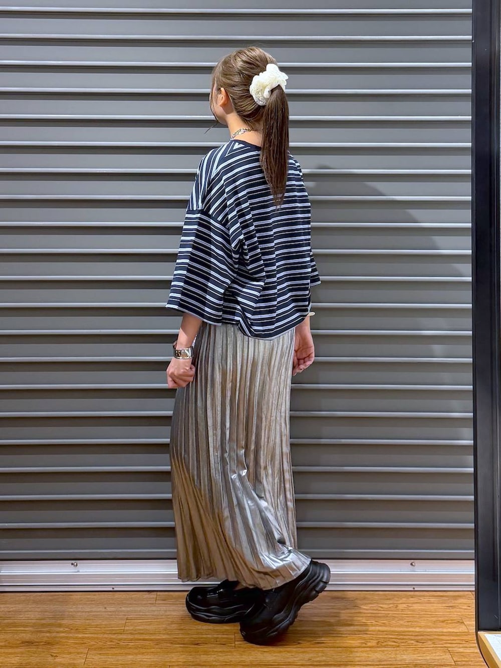 ブラック系のローファー、シルバー系のスカート、ブルー系のTシャツ/カットソーを着用したレディースの夏コーディネートの3枚目の写真