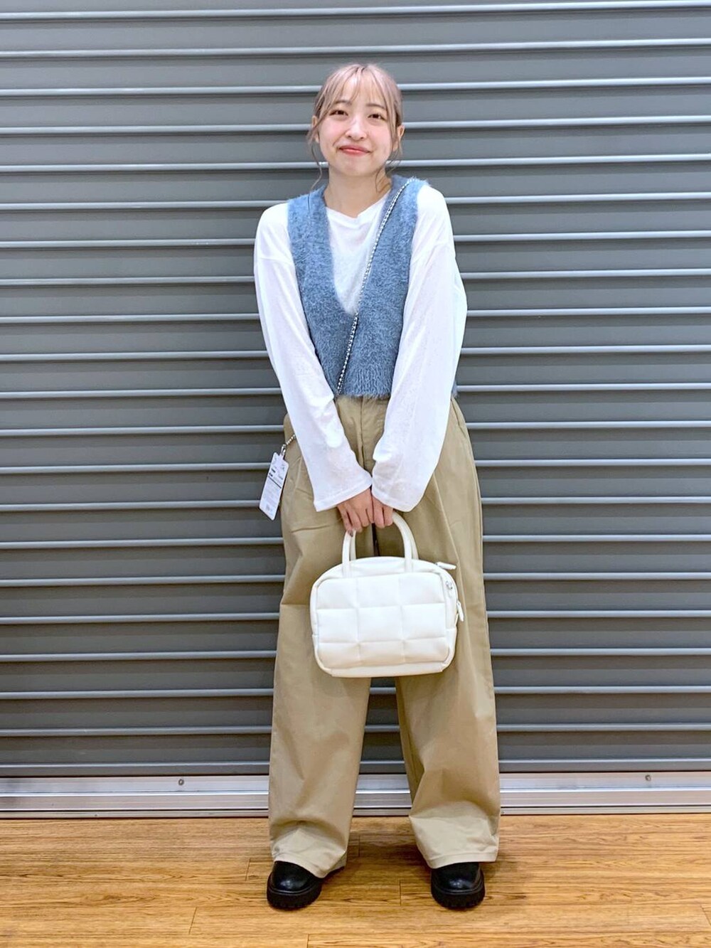 ホワイト系のTシャツ/カットソー、ブラック系のブーツ、ブルー系のベストを着用したレディースの秋コーディネートの6枚目の写真