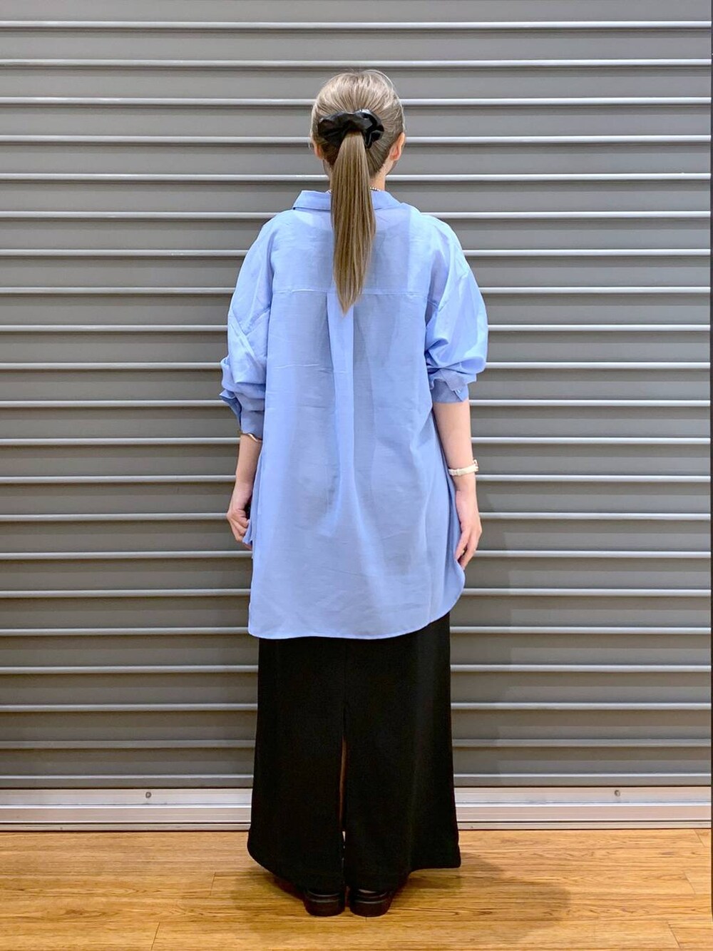 ホワイト系のサンダル、ブラック系のショルダーバッグ、ブルー系のシャツ/ブラウスを着用したレディースの夏コーディネートの2枚目の写真