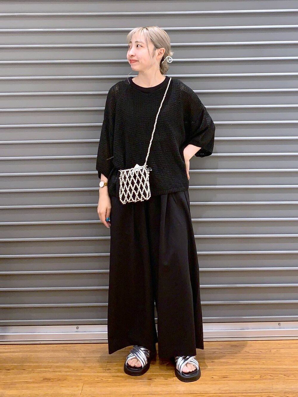 シルバー系のサンダル、ブラック系のスラックス、ブラック系のニット/セーターを着用したレディースの夏コーディネートの5枚目の写真