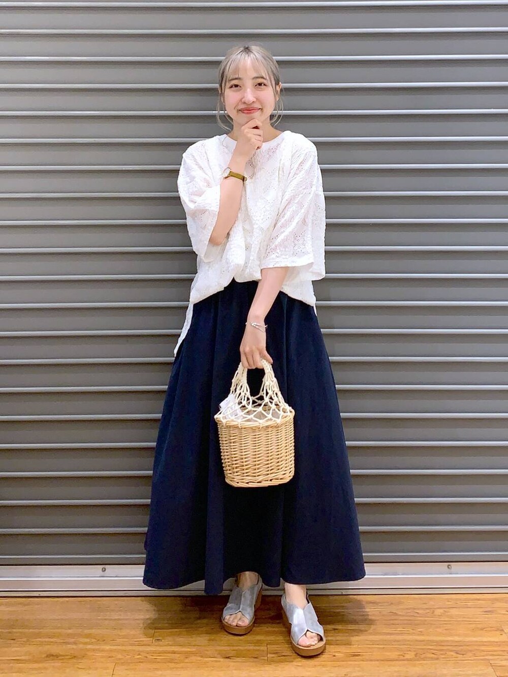 ブルー系のスカート、シルバー系のサンダル、ホワイト系のかごバッグを着用したレディースの夏コーディネートの4枚目の写真