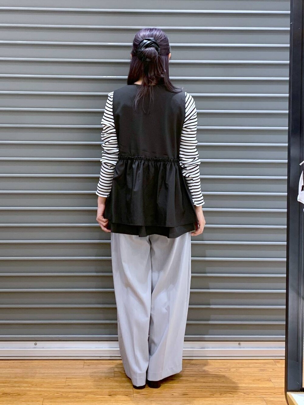 ブラック系のショルダーバッグ、ブラック系のパンプス、ブラック系のベストを着用したレディースの春コーディネートの2枚目の写真