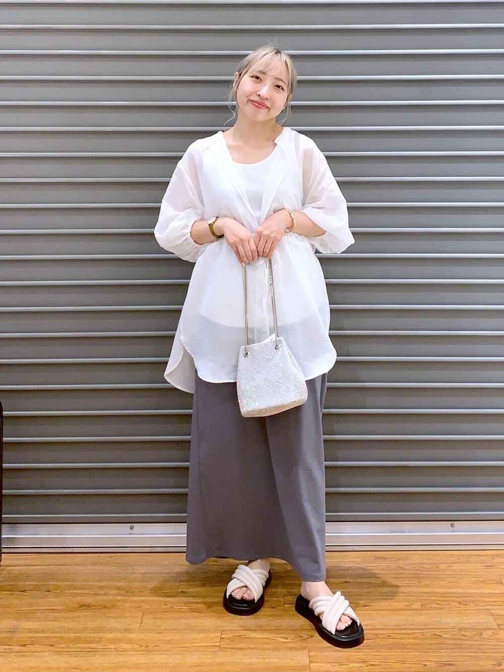 ホワイト系のショルダーバッグ、グレー系のスカート、ホワイト系のサンダルを着用したレディースの夏コーディネートの4枚目の写真