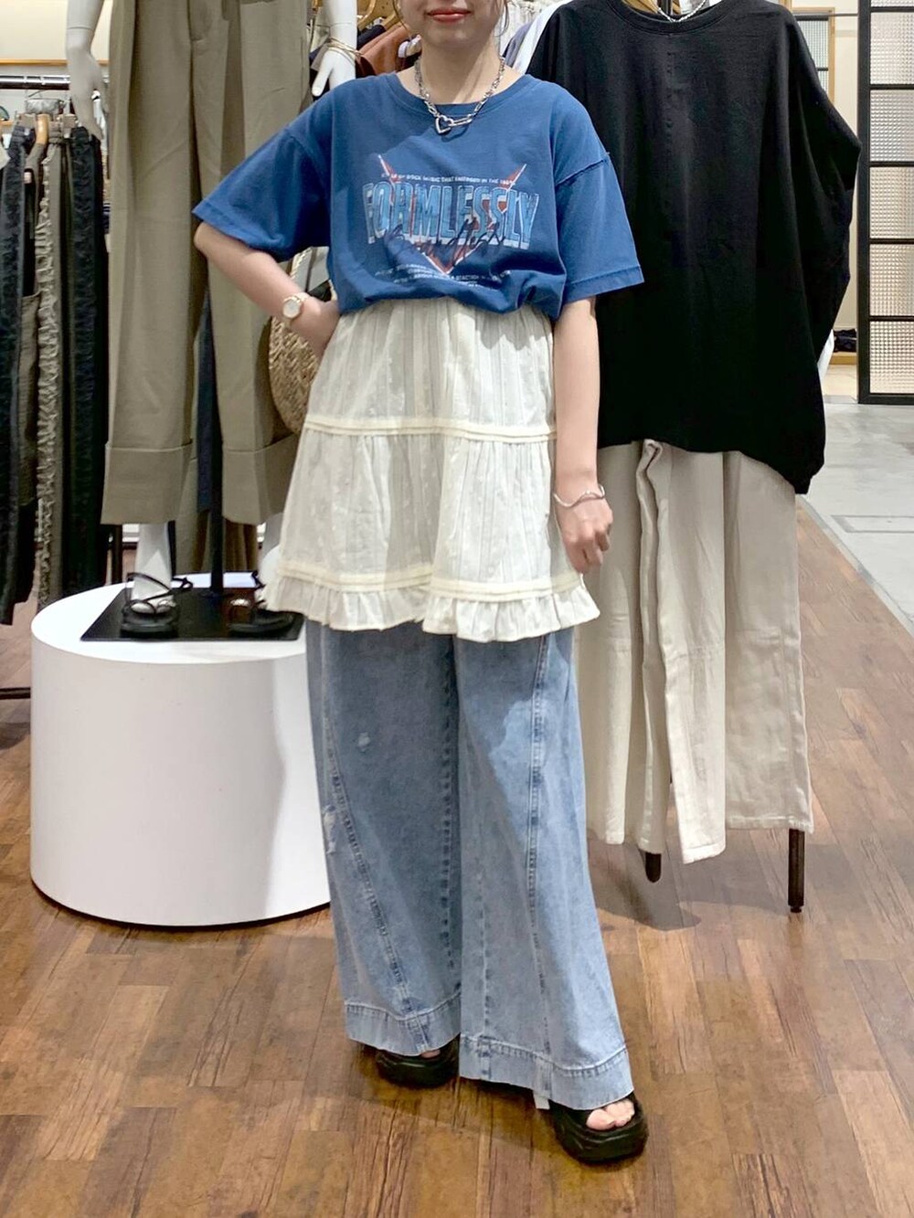 ブルー系のデニムパンツ、ブラック系のサンダル、ブラック系のショルダーバッグを着用したレディースの夏コーディネートの6枚目の写真