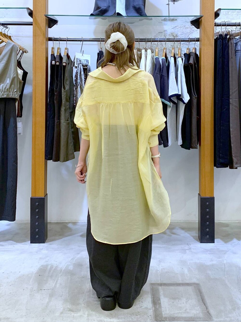 ホワイト系のタンクトップ、ブラック系のショルダーバッグ、イエロー系のシャツ/ブラウスを着用したレディースの秋コーディネートの2枚目の写真