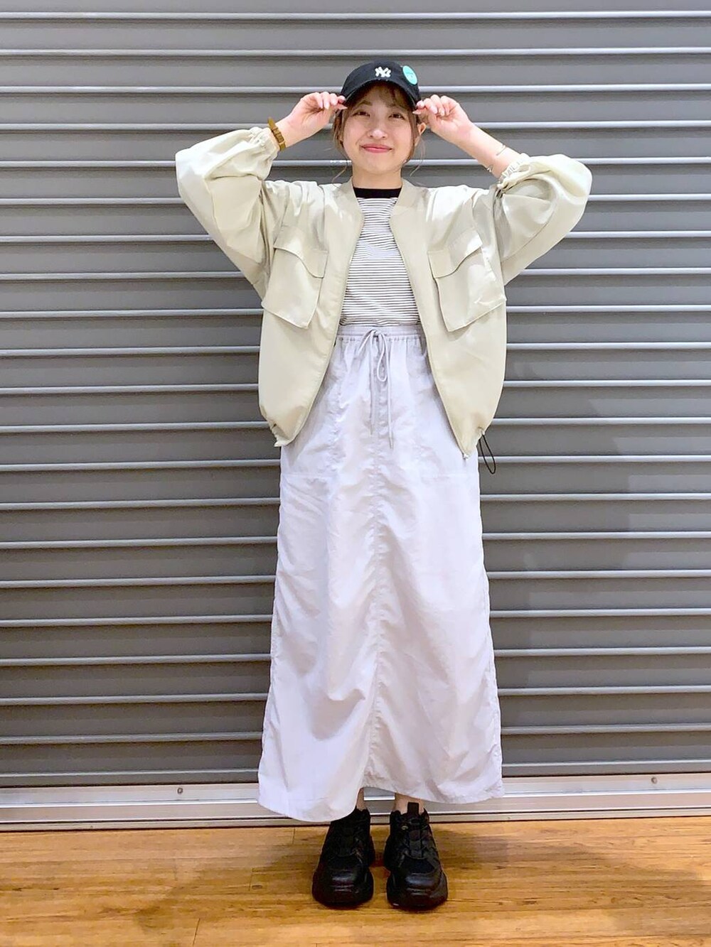 ブラック系のスニーカー、グレー系のTシャツ/カットソー、グレー系のスカートを着用したレディースの春コーディネートの7枚目の写真