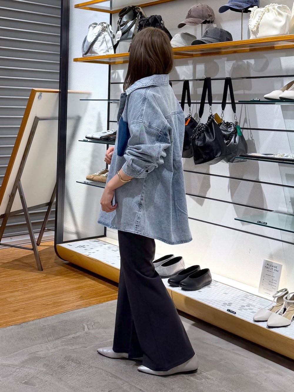 ブラック系のボストンバッグ、シルバー系のパンプス、ブルー系のシャツ/ブラウスを着用したレディースの冬コーディネートの3枚目の写真