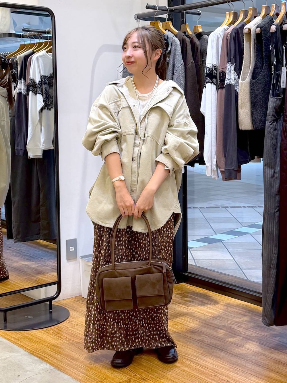 ブラウン系のボストンバッグ、ブラウン系のローファー、ホワイト系のTシャツ/カットソーを着用したレディースの秋コーディネートの4枚目の写真