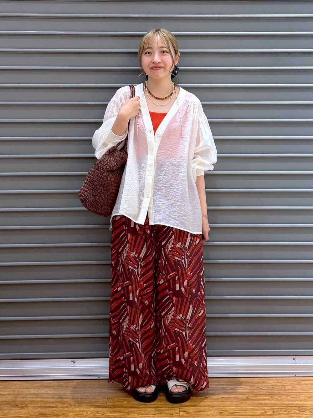 レッド系のその他パンツ、ホワイト系のサンダル、ベージュ系のシャツ/ブラウスを着用したレディースの夏コーディネートの6枚目の写真