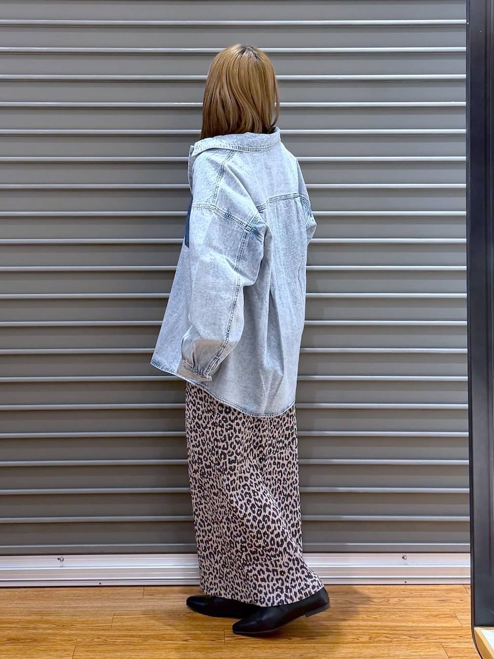 ブラック系のショルダーバッグ、ブルー系のシャツ/ブラウス、ブラック系のパンプスを着用したレディースの春コーディネートの3枚目の写真