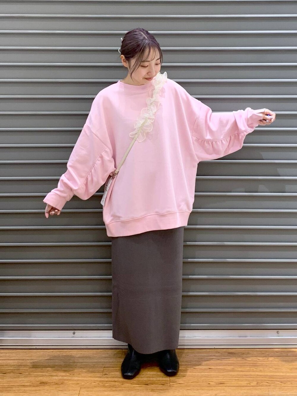 グレー系のスカート、ブラック系のブーツ、ピンク系のスウェットを着用したレディースの冬コーディネートの5枚目の写真