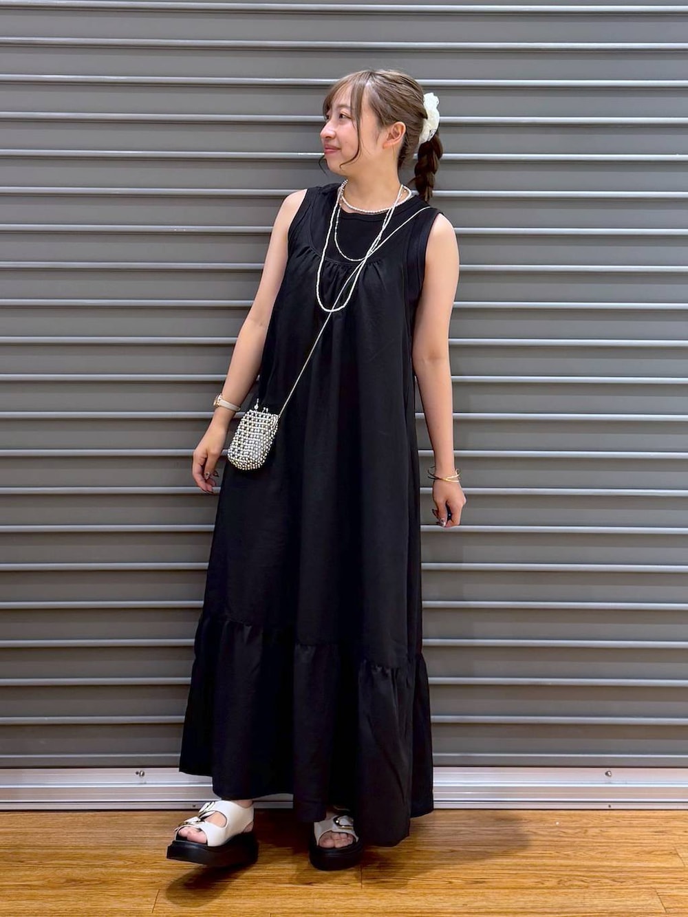 ブラック系のワンピース、ホワイト系のサンダル、ブラック系のタンクトップを着用したレディースの夏コーディネートの5枚目の写真