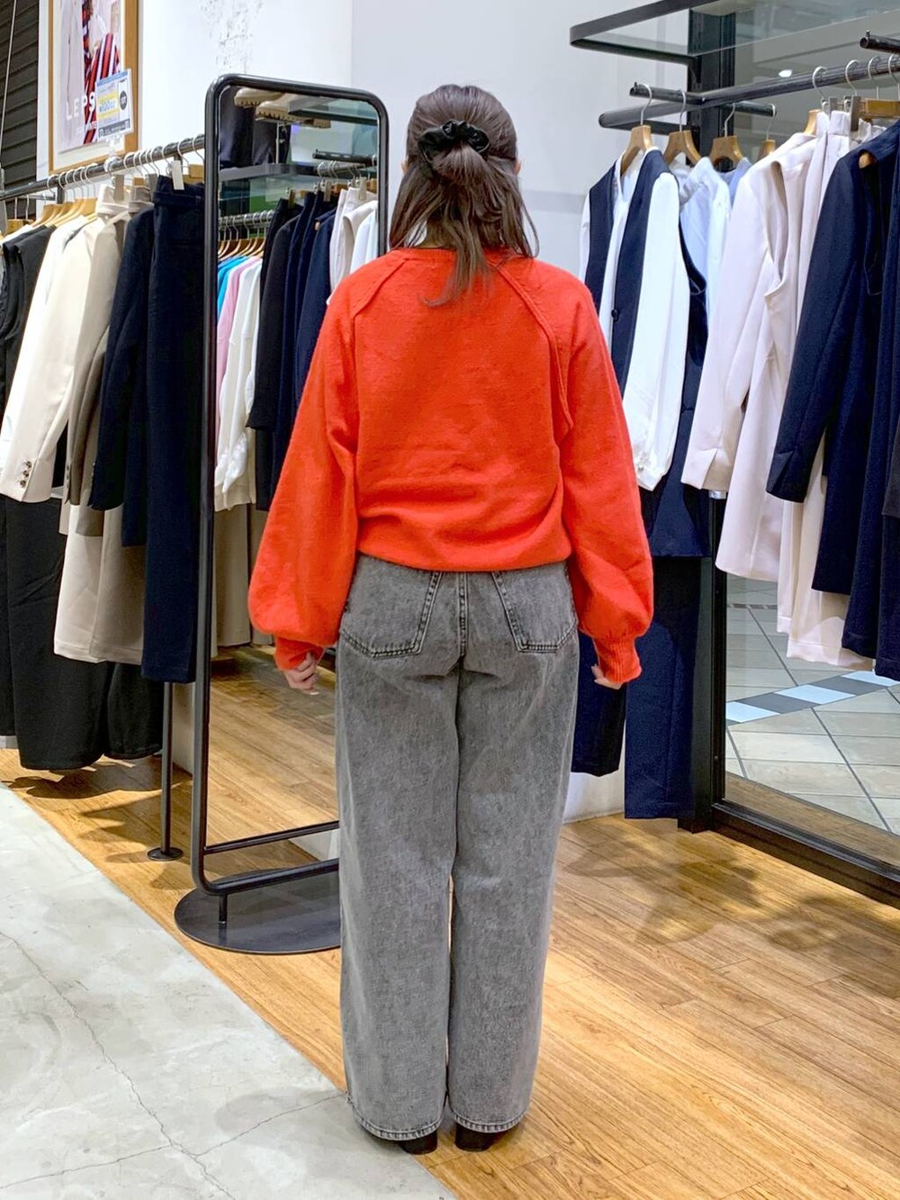 レッド系のニット/セーター、ブラック系のブーツ、その他のショルダーバッグを着用したレディースの冬コーディネートの2枚目の写真