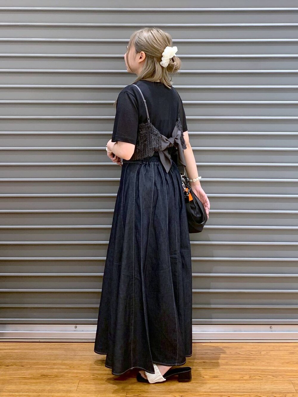 ブルー系のスカート、ホワイト系のサンダル、ブラック系のショルダーバッグを着用したレディースの夏コーディネートの3枚目の写真