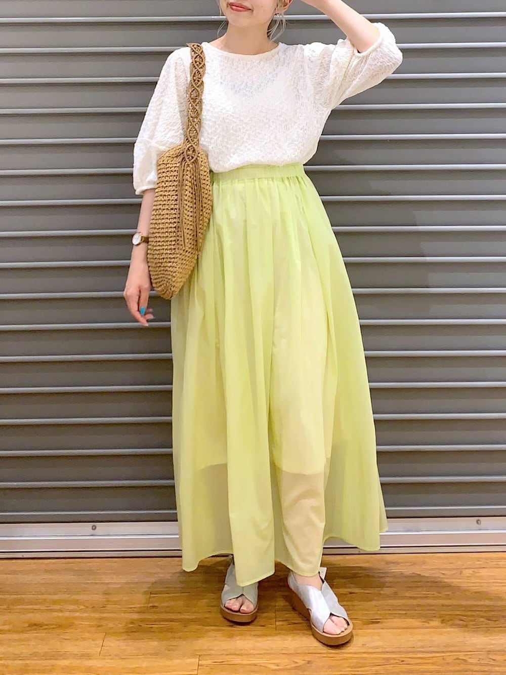 ホワイト系のTシャツ/カットソー、シルバー系のサンダル、イエロー系のスカートを着用したレディースの夏コーディネートの4枚目の写真