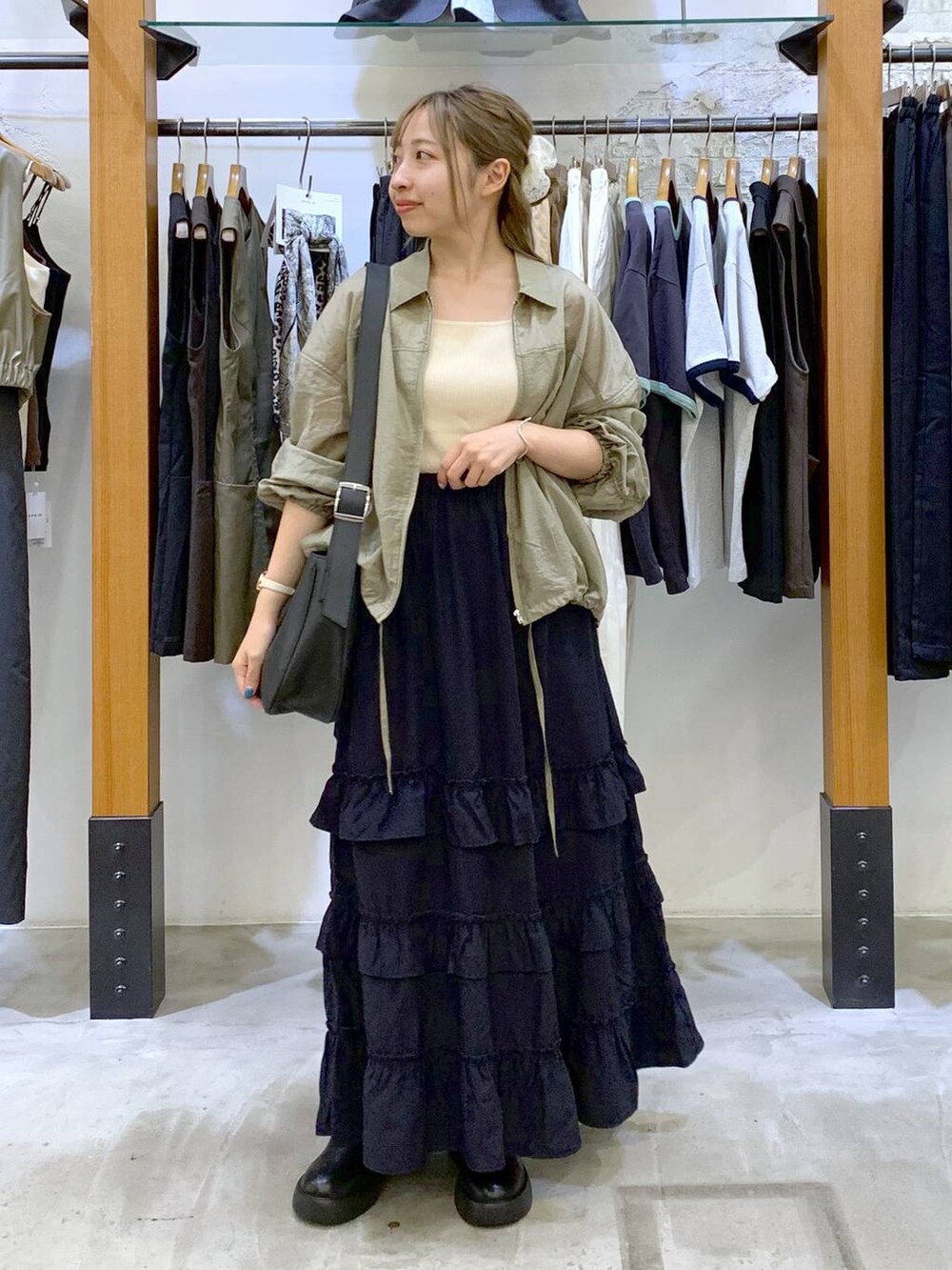 ホワイト系のタンクトップ、ブルー系のスカート、グレー系のショルダーバッグを着用したレディースの秋コーディネートの5枚目の写真