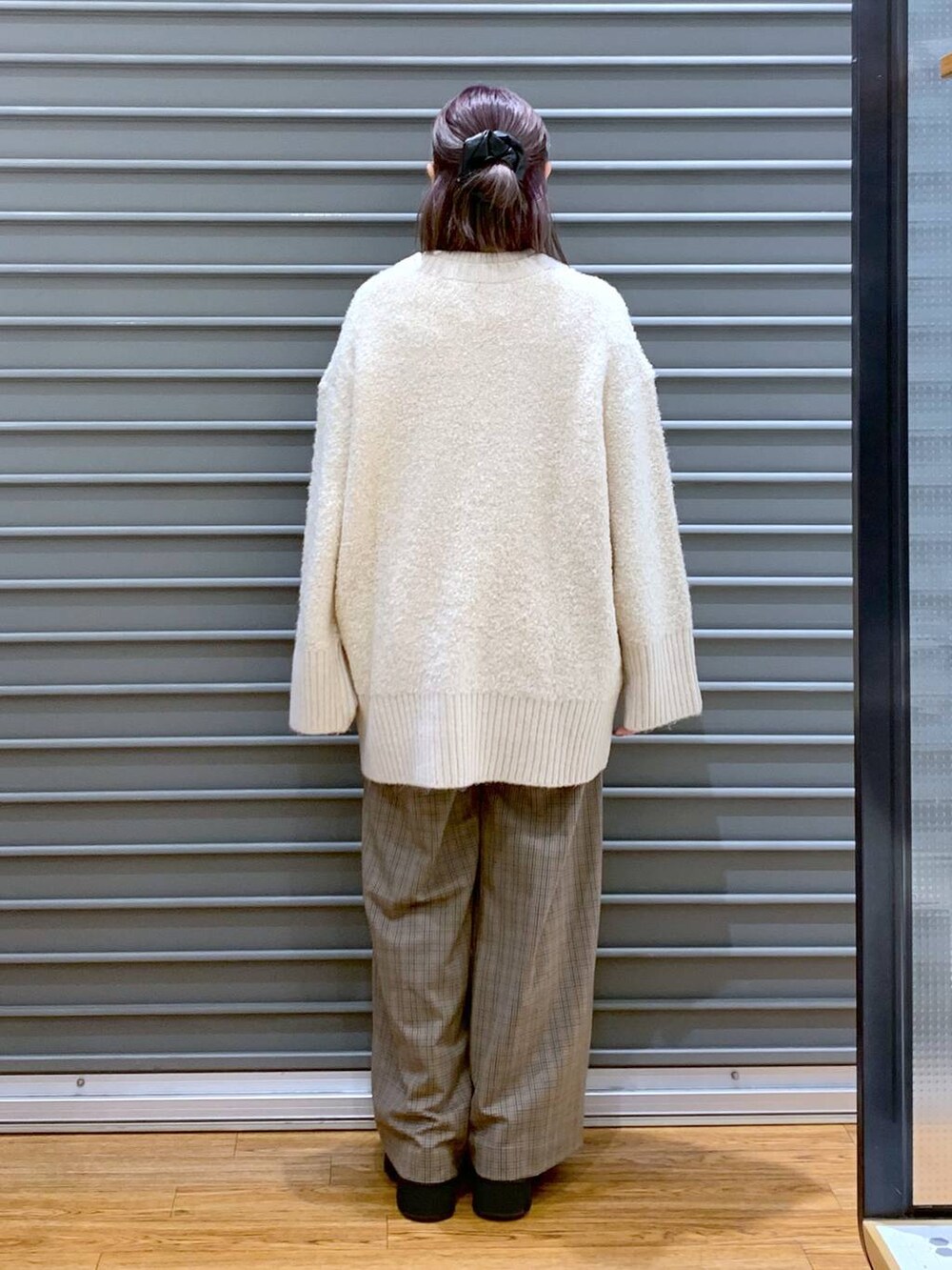 ブラック系のショルダーバッグ、ブラック系のブーツ、ホワイト系のカーディガン/ボレロを着用したレディースの秋コーディネートの2枚目の写真