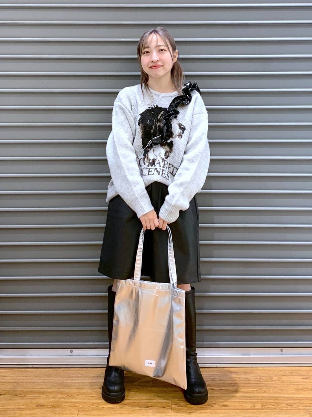 シルバー系のトートバッグ、ブラック系のブーツ、ブラック系のその他パンツを着用したレディースの冬コーディネートの3枚目の写真