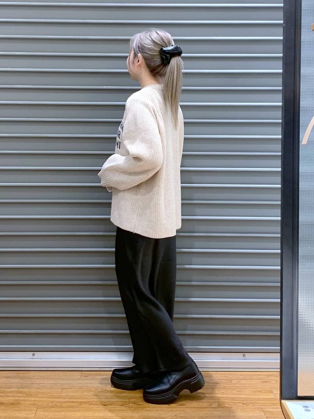 ブラック系のスカート、ブラック系のブーツ、ブラック系のトートバッグを着用したレディースの冬コーディネートの3枚目の写真