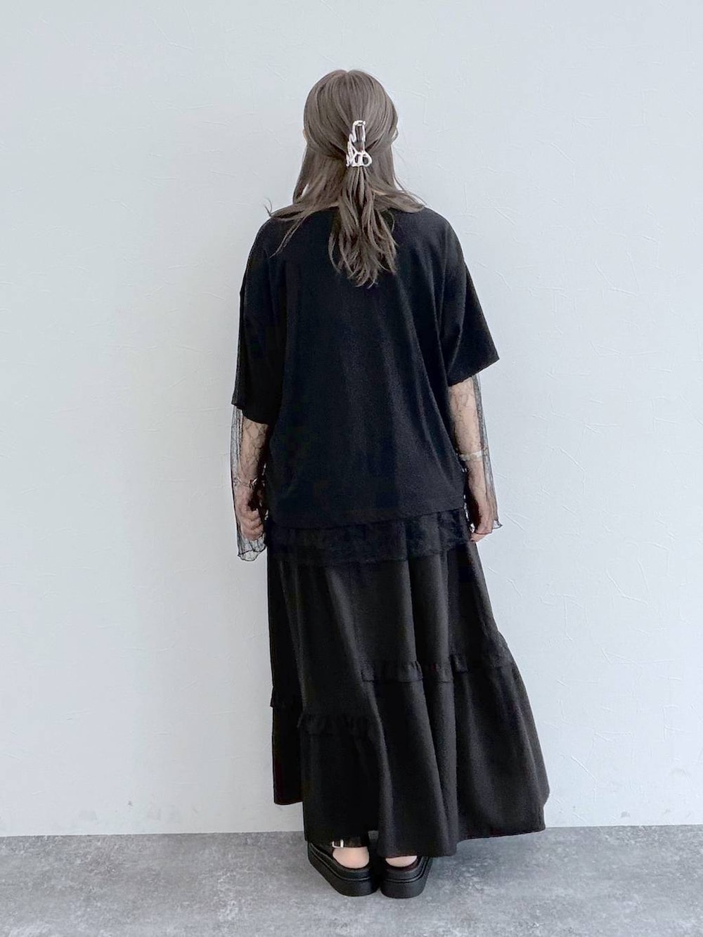 グレー系のショルダーバッグ、ブラック系のサンダル、ブラック系のスカートを着用したレディースの夏コーディネートの2枚目の写真