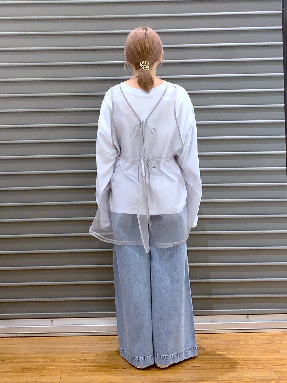 ブルー系のデニムパンツ、ホワイト系のバレエシューズ、イエロー系のショルダーバッグを着用したレディースの春コーディネートの2枚目の写真