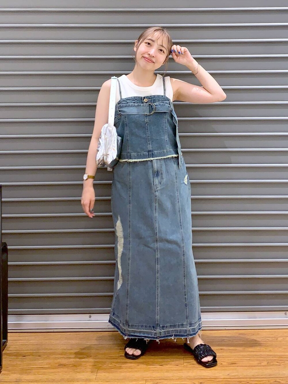 シルバー系のショルダーバッグ、ブラック系のサンダル、ホワイト系のタンクトップを着用したレディースの夏コーディネートの4枚目の写真