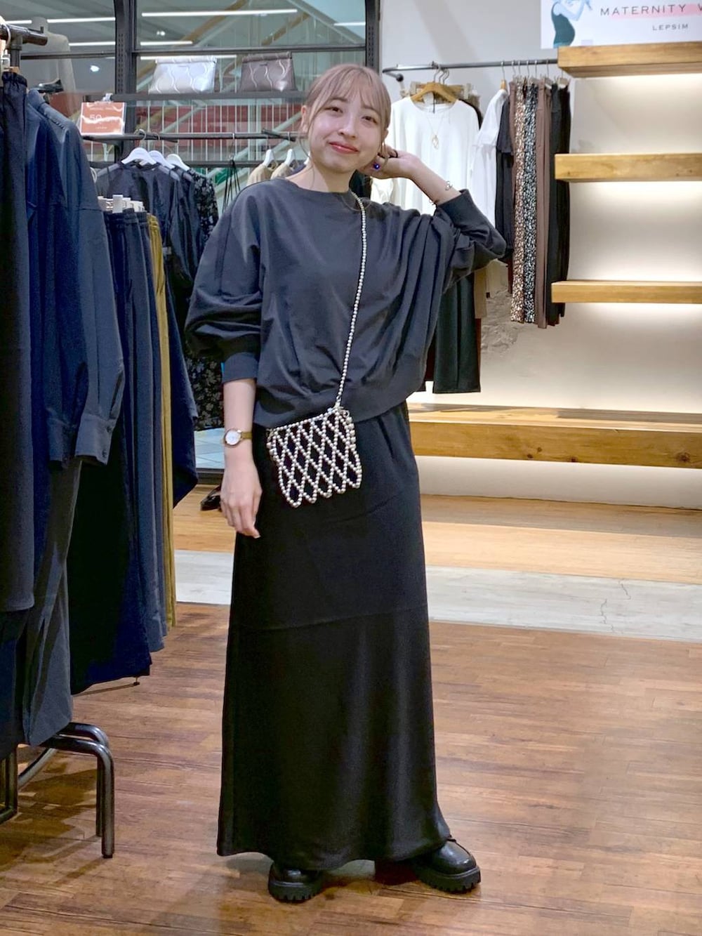 シルバー系のショルダーバッグ、ブラック系のスカート、ブラック系のローファーを着用したレディースの秋コーディネートの3枚目の写真